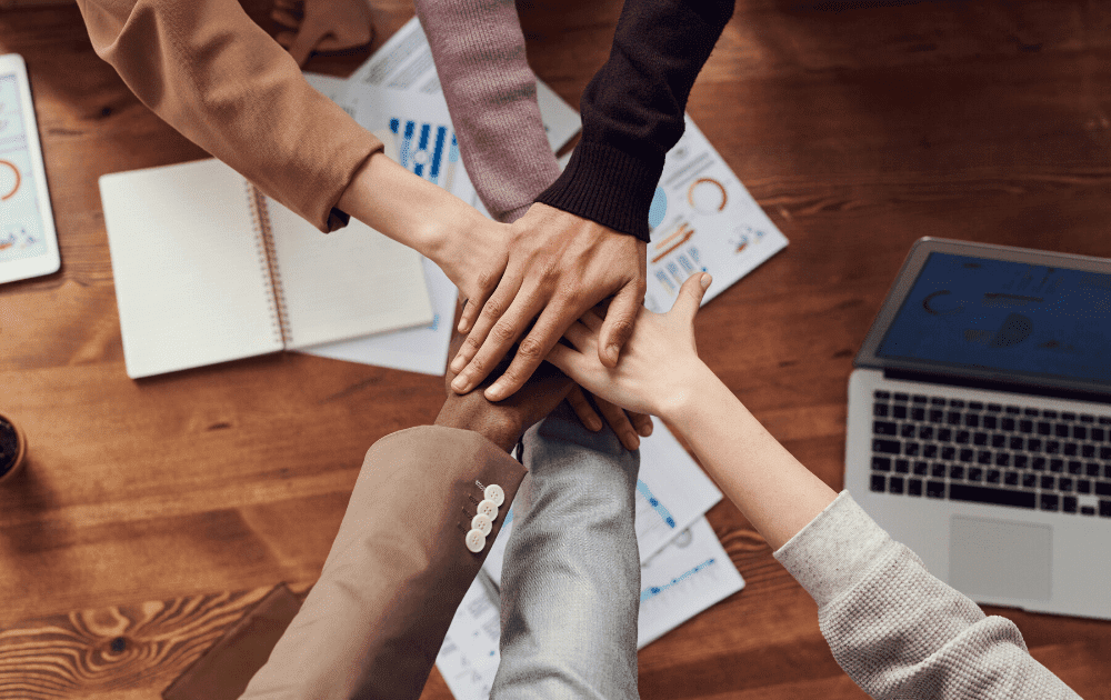 People showing unity by putting hands on top of each others